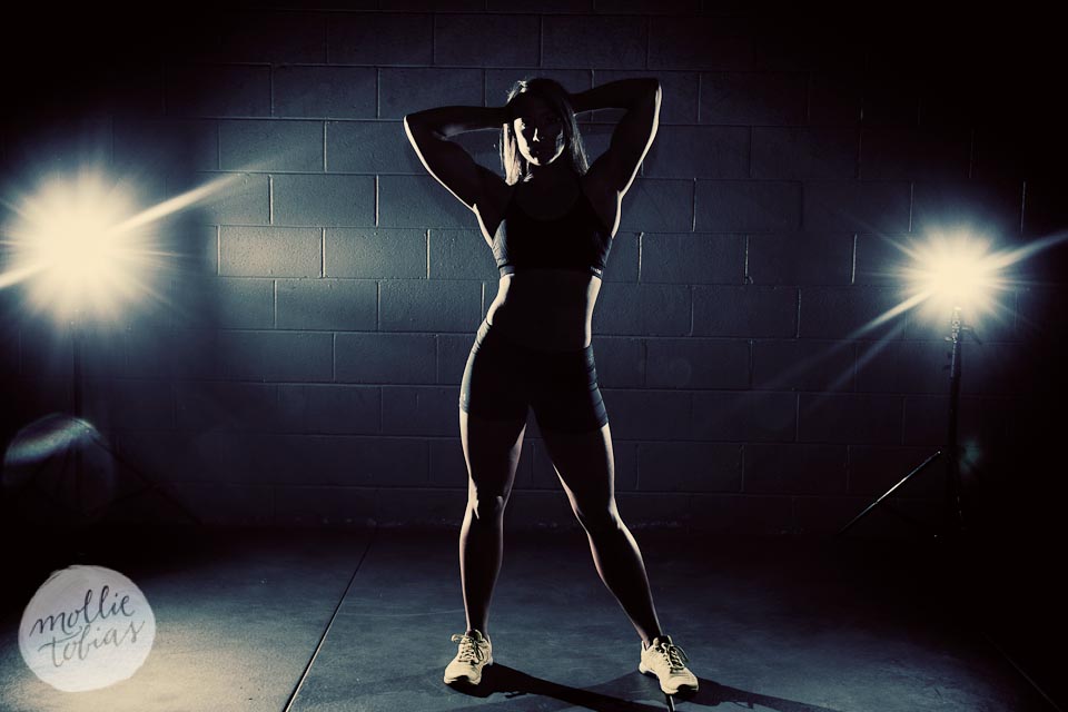 dramatically back lit sports portrait of a fit woman