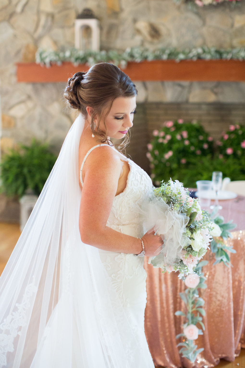 bride with trailing bouquet in front of stone fireplace at the Wallace wedding venue in Aberdeen