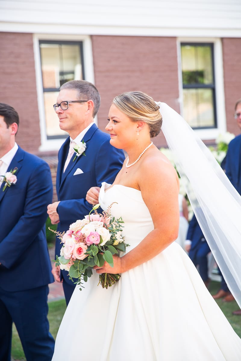 bride and dad walking down aisle at Holly Inn courtyard wedding