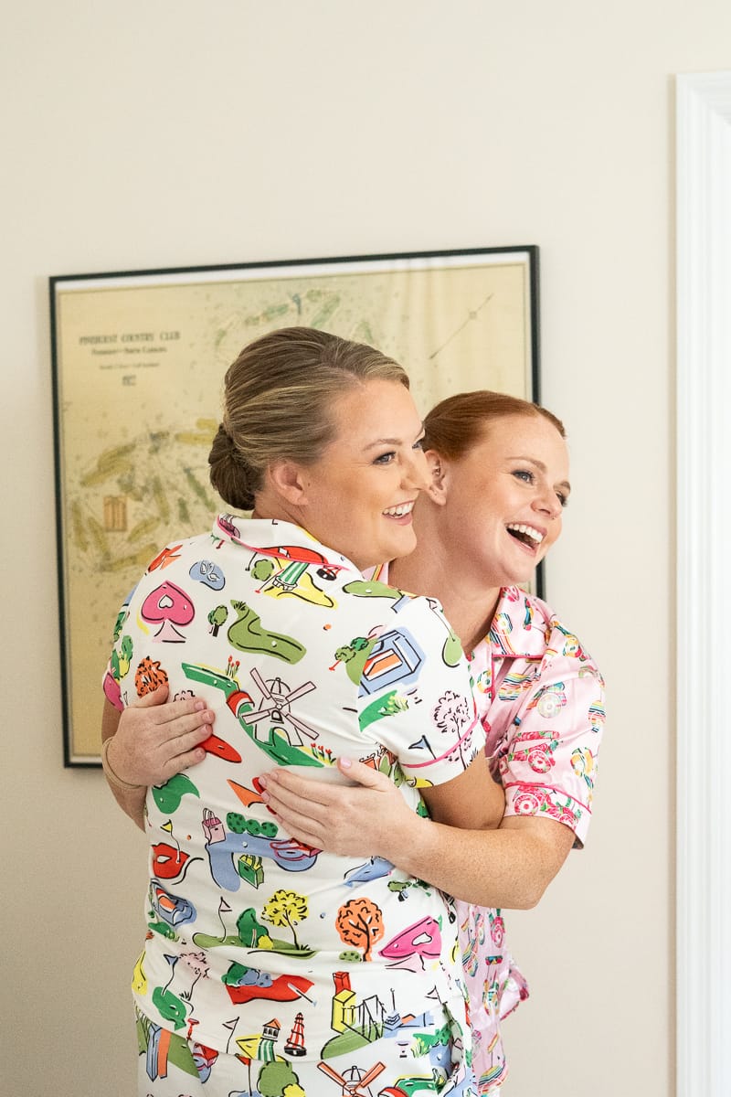 bride and sister hugging at Holly Inn wedding wearing golf themed pajamas