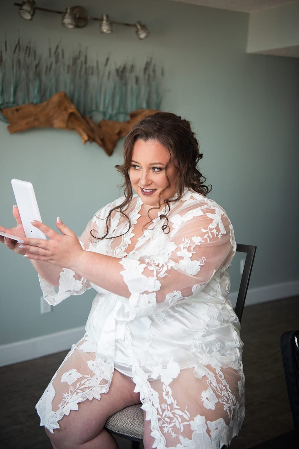 women wearing lace robe for brides while getting ready for a NC beach wedding at Shell Island Resort in Wrightsville Beach, nc