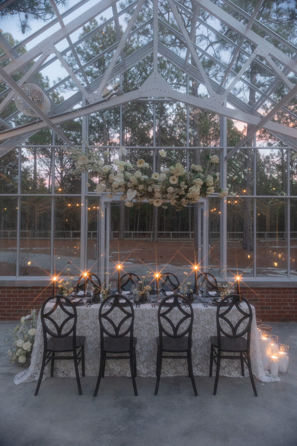 glass greenhouse wedding venue with floating floral display