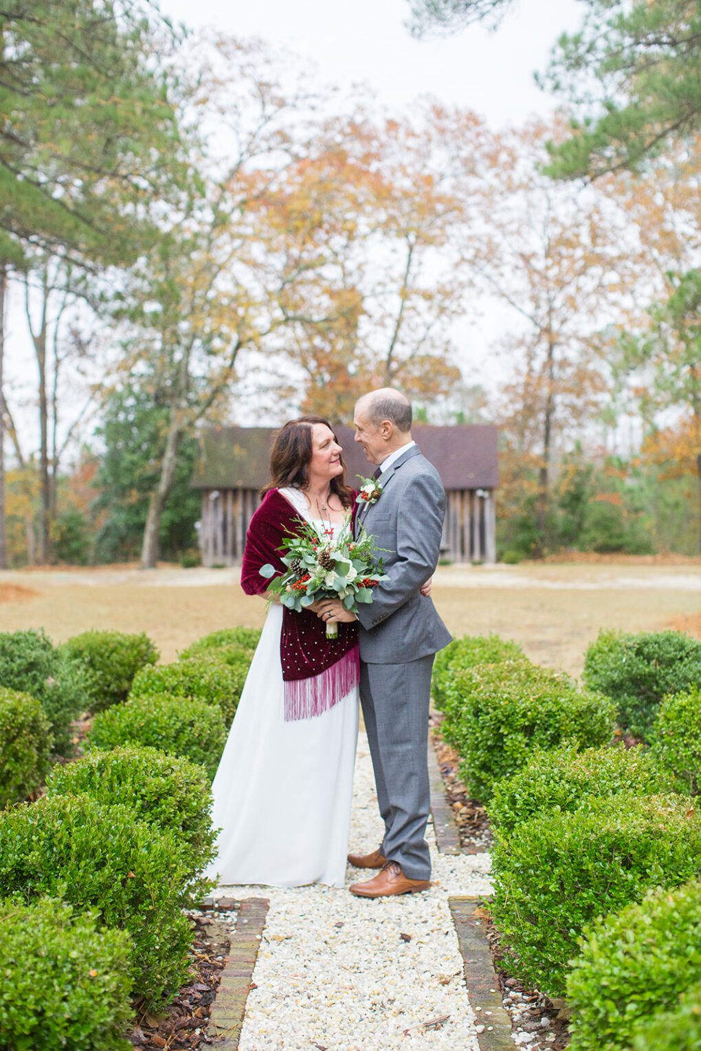 couple on rock path in front of historic farm buildings during a wedding at Rubicon farm