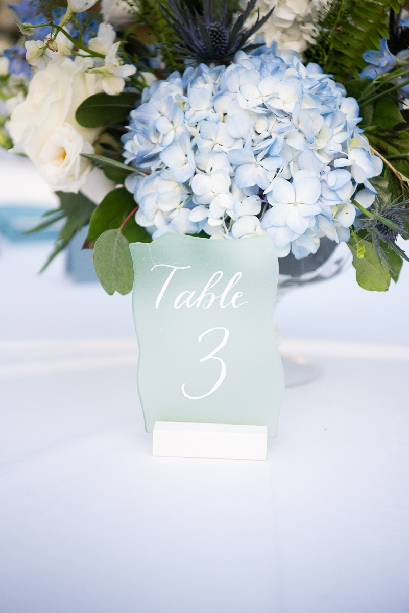 Blue and white floral centerpiece with a table number at a Pinehurst wedding reception.