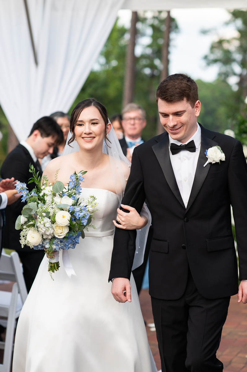 Bride and groom walking down the aisle hand in hand at their Pinehurst wedding.