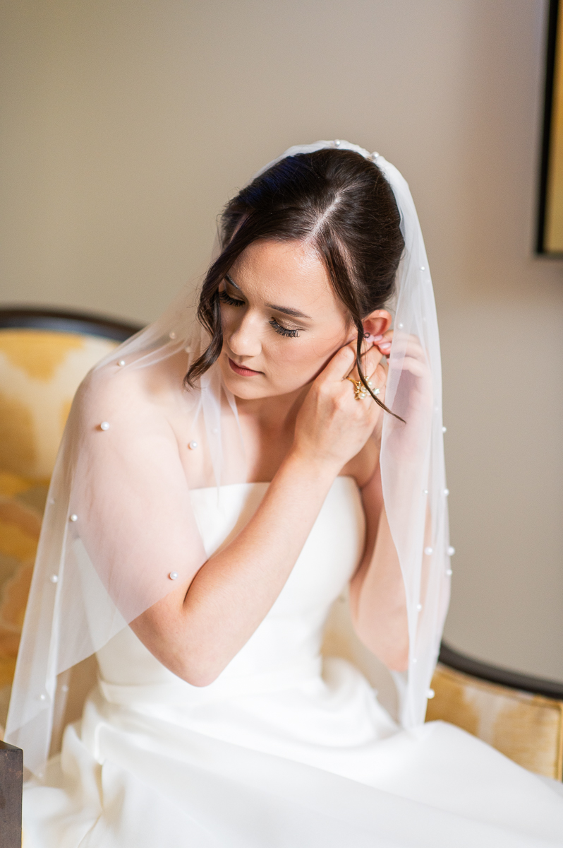 Bride touching her veil in a quiet moment before her Pinehurst wedding ceremony.