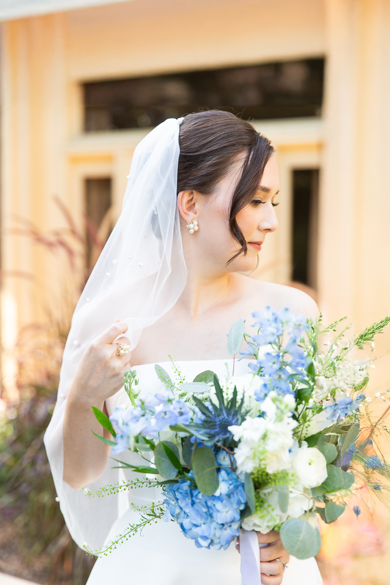 Bride with a bouquet featuring blue and white flowers at her wedding in Pinehurst.