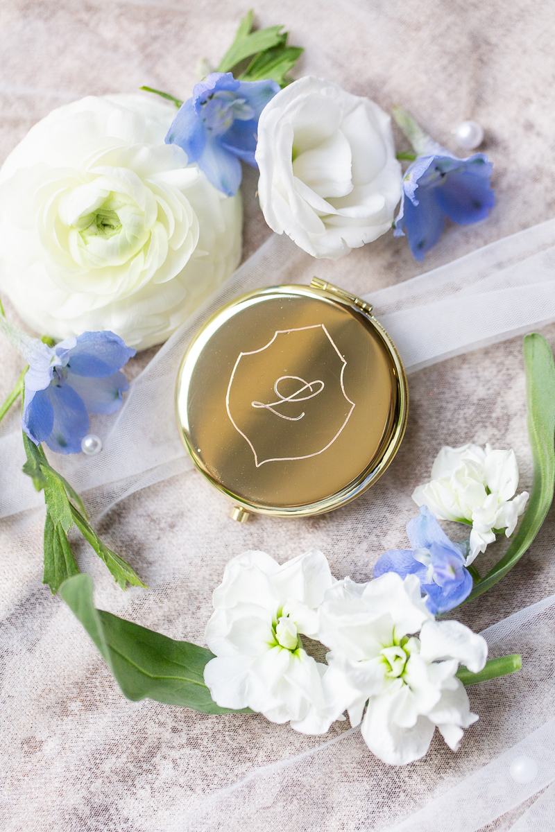 Close-up of blue and white wedding details with florals and gold accents at a Pinehurst wedding.