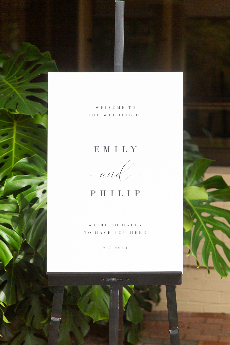 Wedding welcome sign at the Country Club of North Carolina in Pinehurst, NC, surrounded by lush greenery.