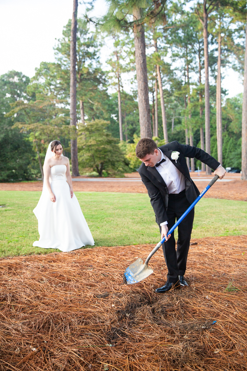 Groom burying bourbon in a traditional Southern wedding ritual at the Country Club of North Carolina.