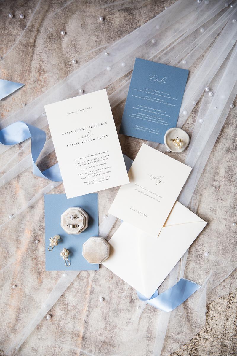 Flat lay of elegant wedding invitations with blue and white accents