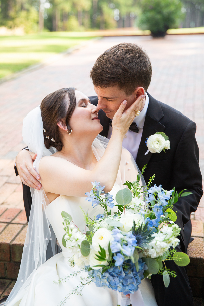 Romantic photo of the bride and groom kissing in a garden at the Country Club of North Carolina.