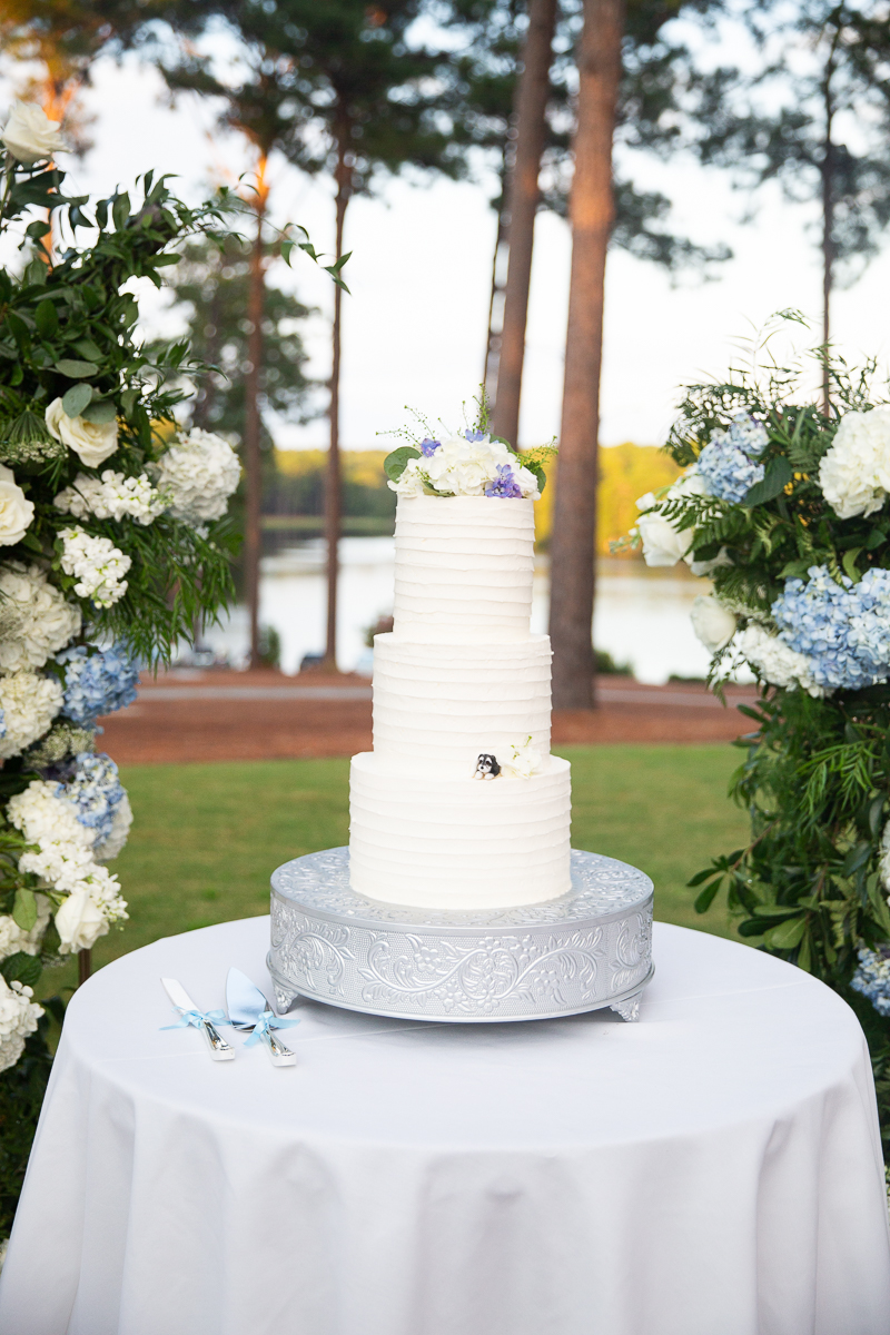 Wedding cake on display with blue and white florals at the Country Club of North Carolina.