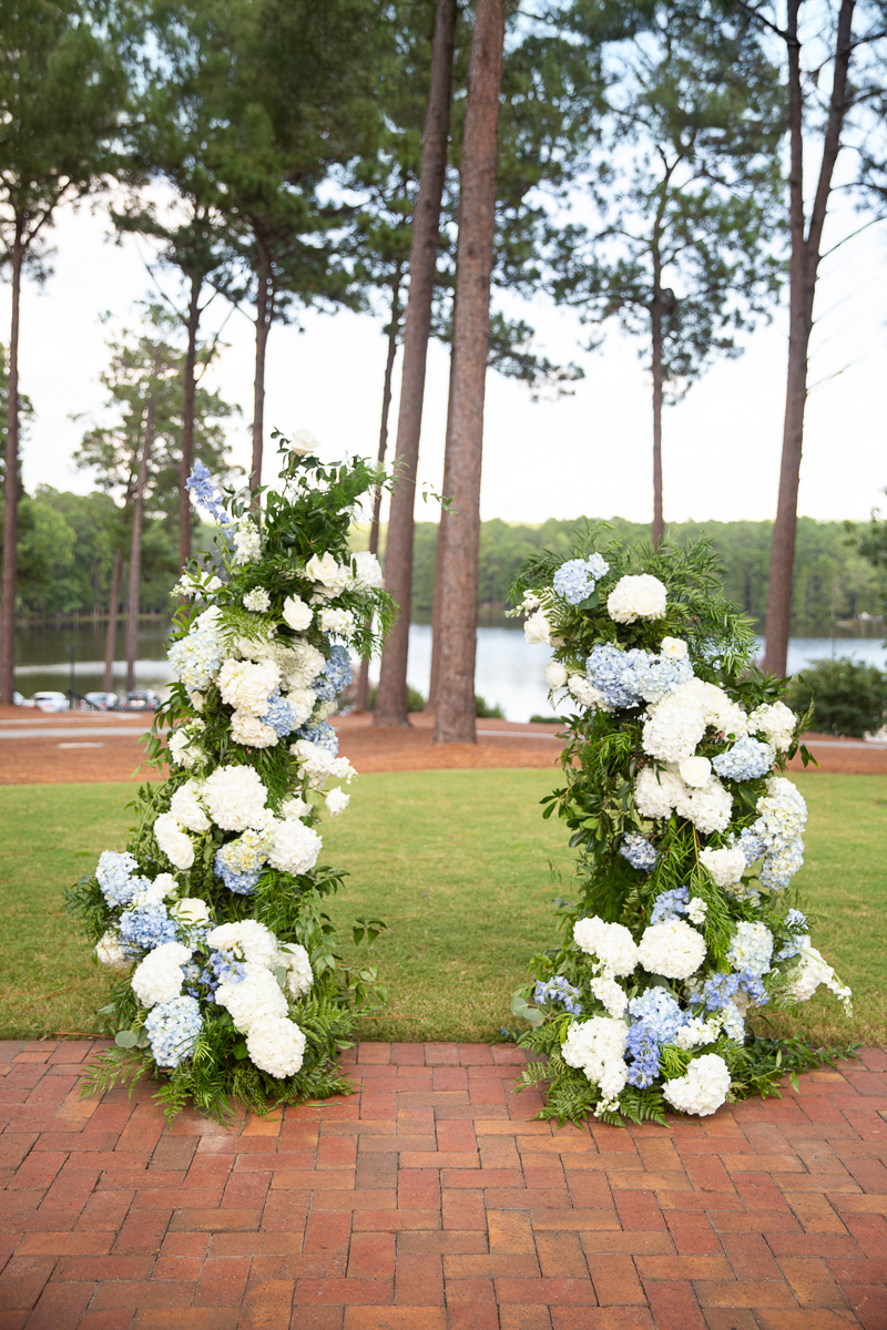 Wedding ceremony floral arch with blue and white details at the Country Club of North Carolina.