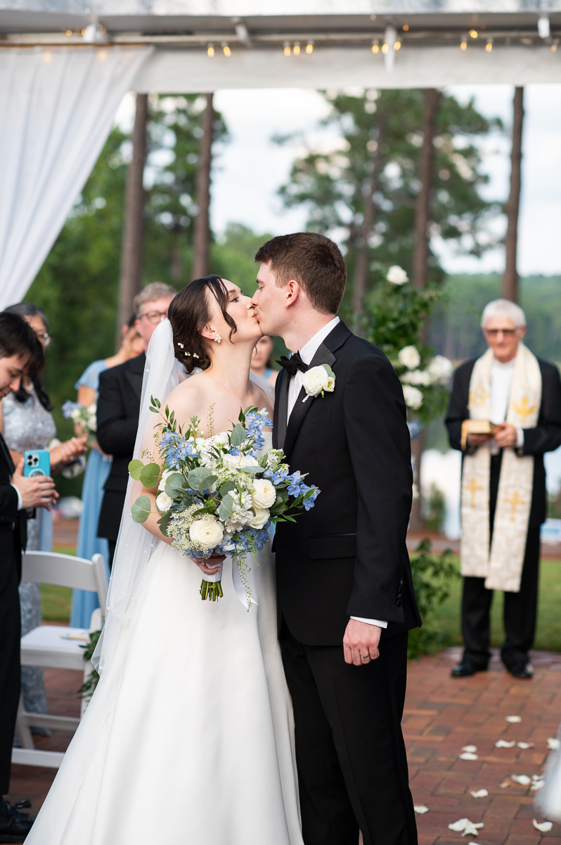 Bride and groom sharing their first kiss during the ceremony at the Country Club of North Carolina.