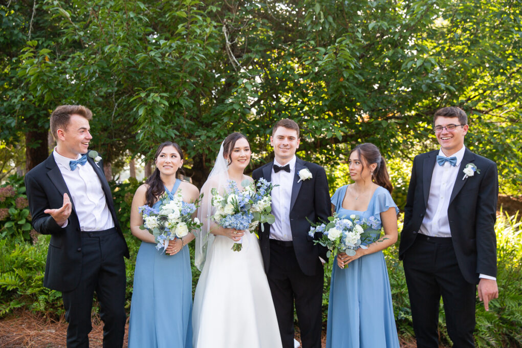 Wedding party posing outdoors with blue and white attire at the Country Club of North Carolina.