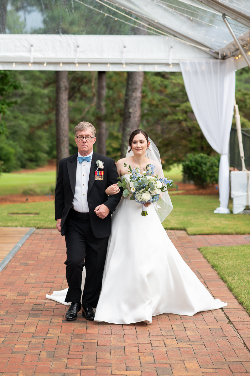 bride and dad smiling as they walk down the aisle during the processional in Pinehurst, NC.