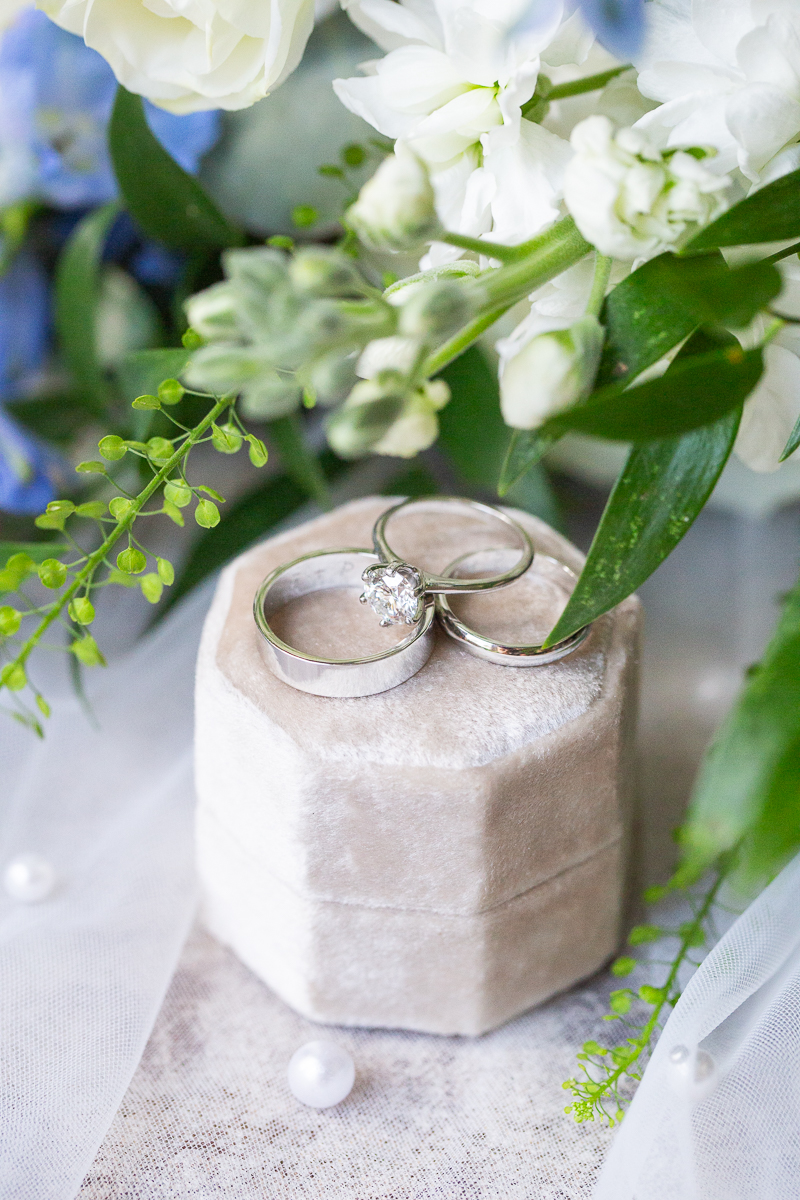 Wedding rings surrounded by green and white florals